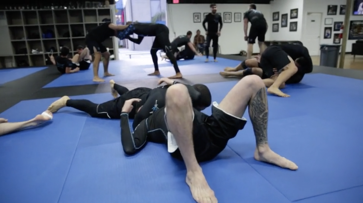 Andre Galvao rolling during No-Gi class With one of his purple belts Taylor Cook