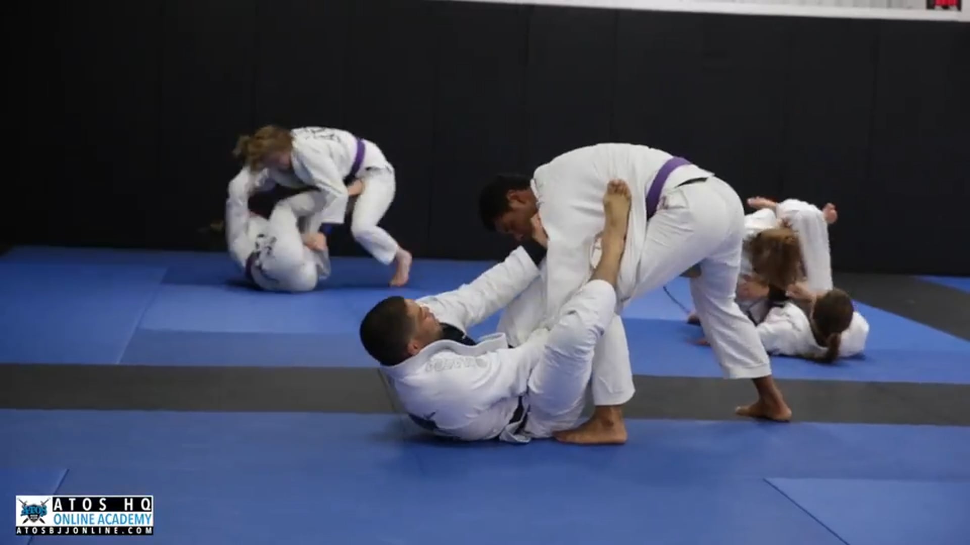 Sparring professor Andre Galvao rolling with a purple belt 