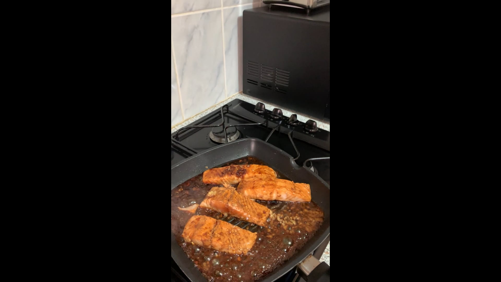 Salmon slices in soy sauce with fresh basil