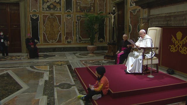 Un niño se sienta a los pies del Papa...