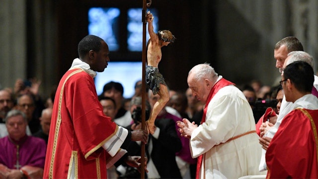 Pope Francis stands to kiss the cross during the Good Friday liturgy
