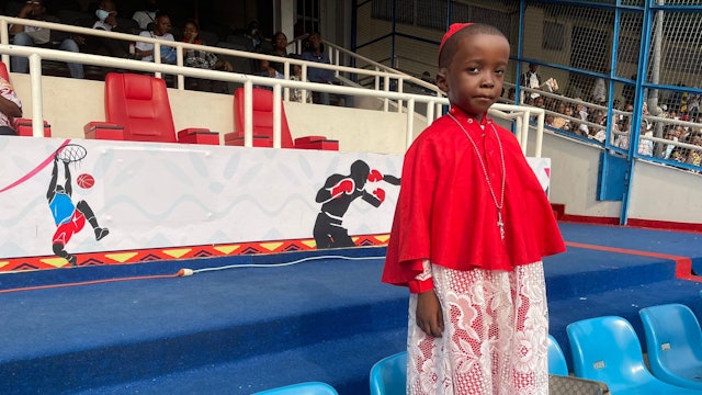 A child dressed as cardinal among the pilgrims who welcomed the Pope with joy
