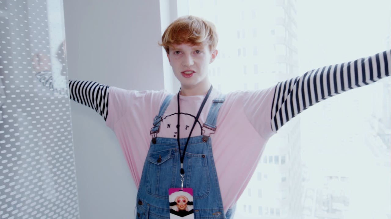 Scaredy Kat serving out of drag, dungarees, standing in the street